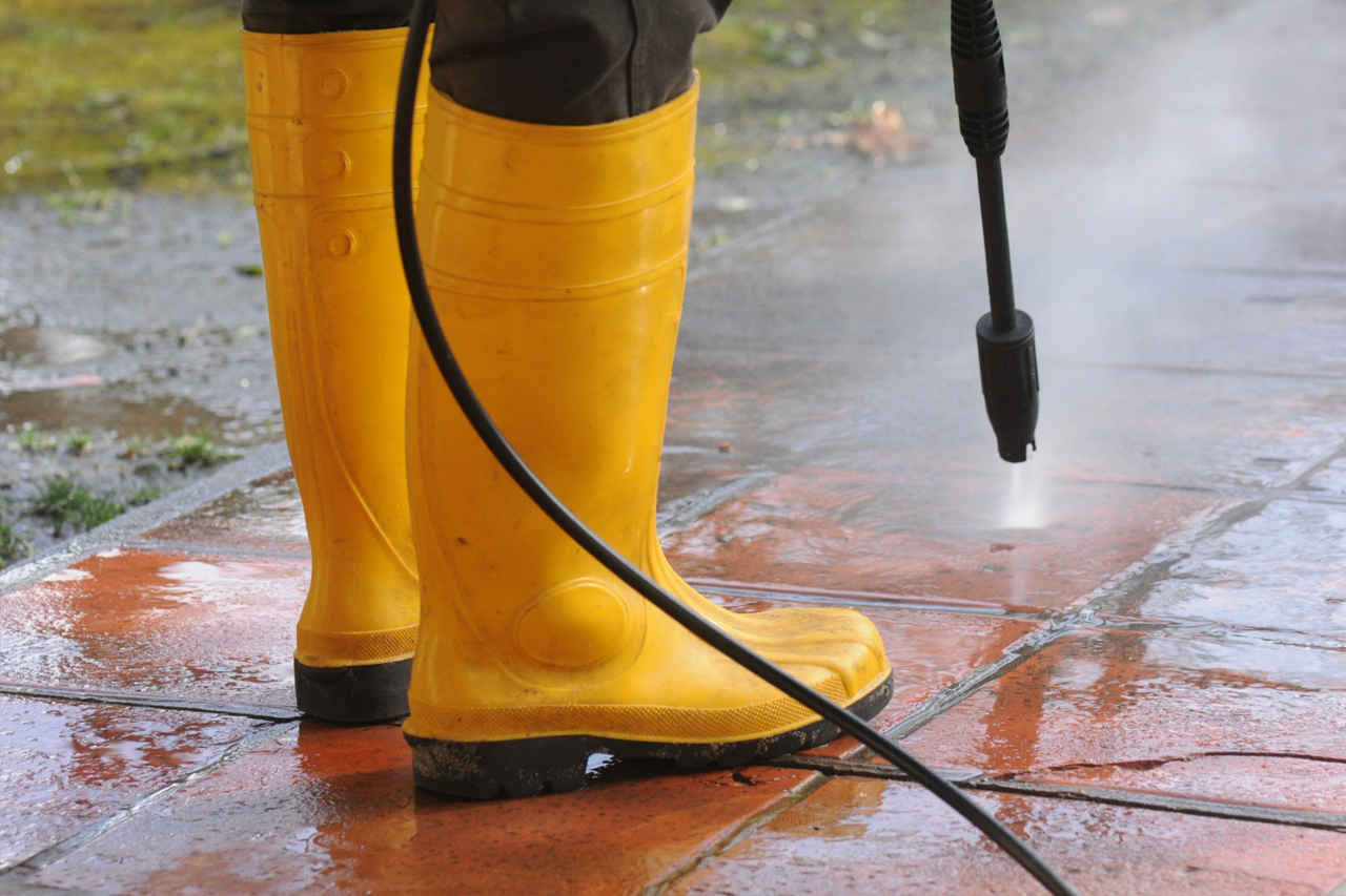 Man cleaning red brick with pressure washer in Saratoga, NY